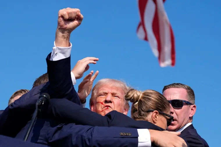 Donald Trump's assassination attempt Trump with his fist in the air after a near miss with a bullet